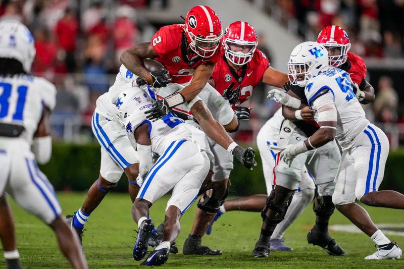 Oct 7, 2023; Athens, Georgia, USA; Georgia Bulldogs running back Kendall Milton (2) jumps over Kentucky Wildcats defensive back Jordan Lovett (25) during the second half at Sanford Stadium. Mandatory Credit: Dale Zanine-USA TODAY Sports