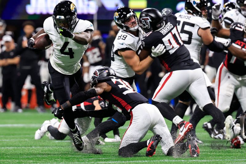 Atlanta Falcons cornerback Natrone Brooks (35) trips up Jacksonville Jaguars running back Tank Bigsby (4) in the first half of an NFL preseason footballl game, Friday, Aug. 23, 2024, in Atlanta. (AP Photo/Butch Dill)