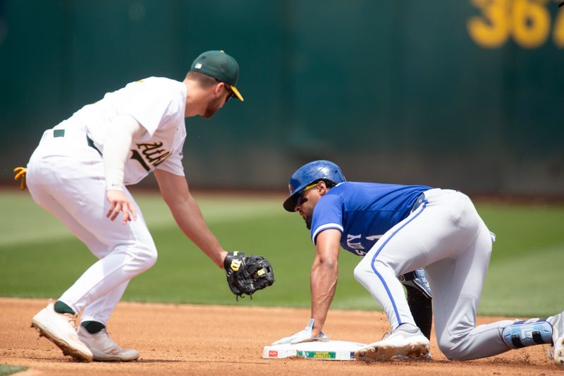 Jun 20, 2024; Oakland, California, USA; Kansas City Royals left fielder MJ Melendez (1) slides safely into second base with a double ahead of the tag by Oakland Athletics shortstop Max Schuemann (12) during the fourth inning at Oakland-Alameda County Coliseum. Mandatory Credit: D. Ross Cameron-USA TODAY Sports