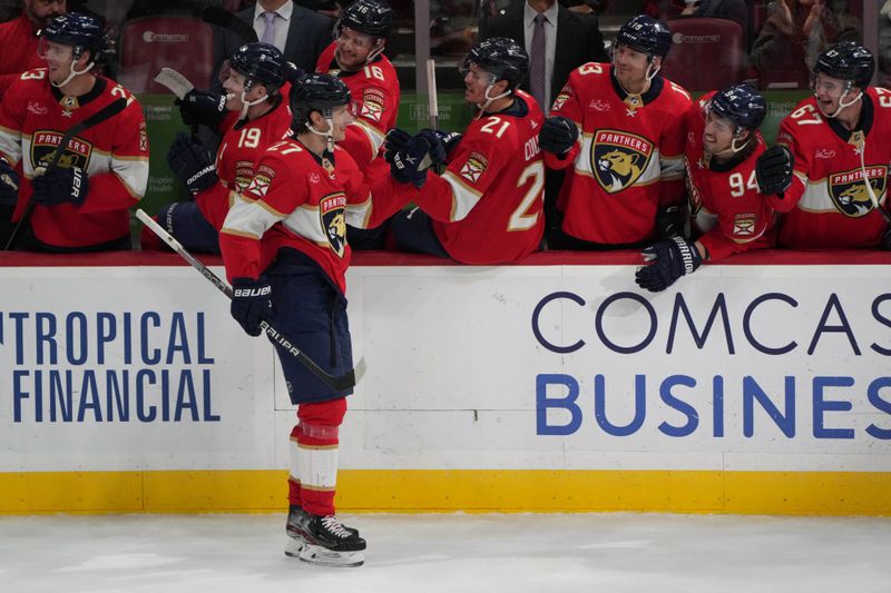 Dec 30, 2023; Sunrise, Florida, USA; Florida Panthers center Eetu Luostarinen (27) is congratulated by teammates after scoring a goal against the Montreal Canadiens during the third period at Amerant Bank Arena. Mandatory Credit: Jim Rassol-USA TODAY Sports