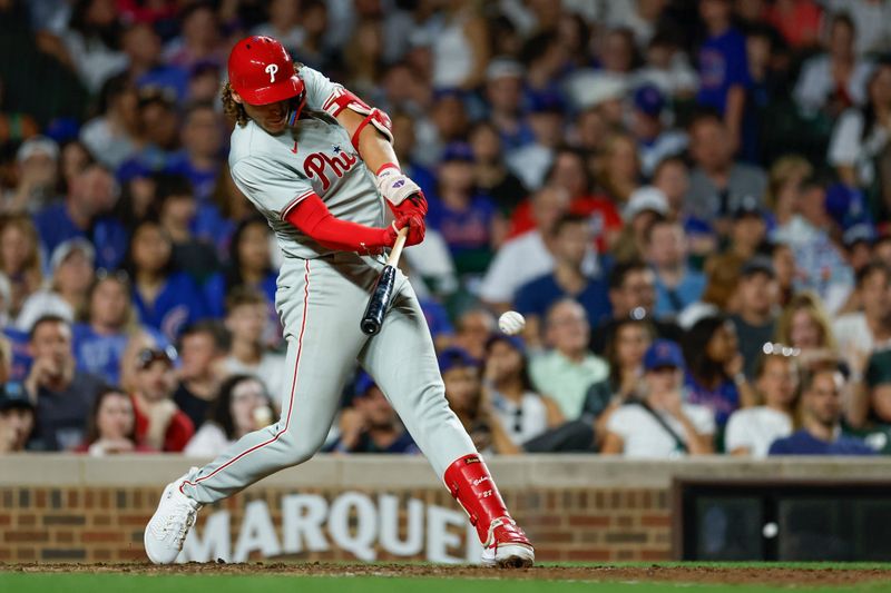 Jul 3, 2024; Chicago, Illinois, USA; Philadelphia Phillies third baseman Alec Bohm (28) singles against the Chicago Cubs during the eight inning at Wrigley Field. Mandatory Credit: Kamil Krzaczynski-USA TODAY Sports