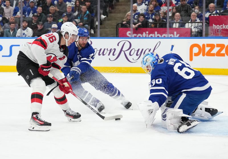 Mar 26, 2024; Toronto, Ontario, CAN; New Jersey Devils center Jack Hughes (86) battles for the puck with Toronto Maple Leafs defenseman TJ Brodie (78) in front of  goaltender Joseph Woll (60) during the second period at Scotiabank Arena. Mandatory Credit: Nick Turchiaro-USA TODAY Sports