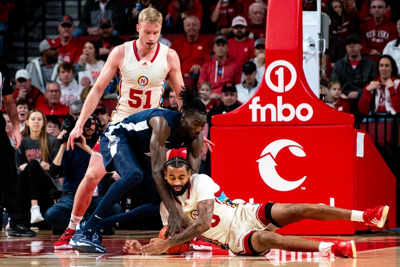 Feb 17, 2024; Lincoln, Nebraska, USA; Nebraska Cornhuskers guard Brice Williams (3) fights for the ball against Penn State Nittany Lions forward Favour Aire (12) during the first half at Pinnacle Bank Arena. Mandatory Credit: Dylan Widger-USA TODAY Sports