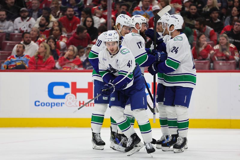 Oct 17, 2024; Sunrise, Florida, USA; Vancouver Canucks defenseman Quinn Hughes (43) celebrates with teammates after scoring against the Florida Panthers during the second period at Amerant Bank Arena. Mandatory Credit: Sam Navarro-Imagn Images