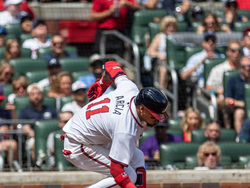 Jun 2, 2024; Cumberland, Georgia, USA;   Atlanta Braves shortstop Orlando Arcia (11) stumbles after a swing and miss against the Oakland Athletics during the eighth inning at Truist Park. Mandatory Credit: Jordan Godfree-USA TODAY Sports
