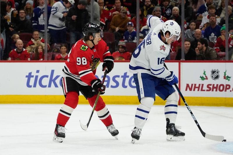 Nov 24, 2023; Chicago, Illinois, USA; Chicago Blackhawks center Connor Bedard (98) and Toronto Maple Leafs right wing Mitchell Marner (16) go for the puck during the first period at United Center. Mandatory Credit: David Banks-USA TODAY Sports