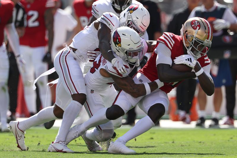 San Francisco 49ers wide receiver Brandon Aiyuk, right, is tackled by Arizona Cardinals cornerback Kei'Trel Clark, left, and cornerback Sean Murphy-Bunting during the first half of an NFL football game in Santa Clara, Calif., Sunday, Oct. 6, 2024. (AP Photo/Jed Jacobsohn)