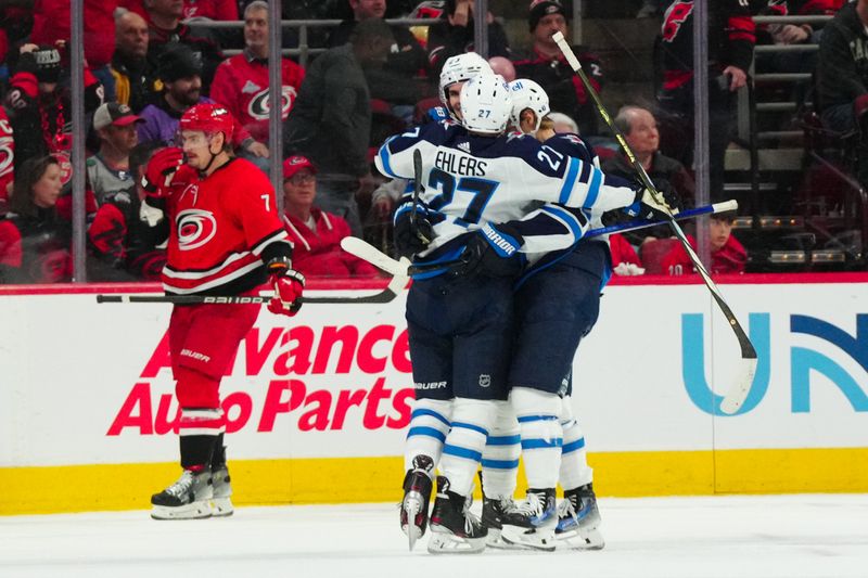 Mar 2, 2024; Raleigh, North Carolina, USA;  Winnipeg Jets center Sean Monahan (23) is congratulated by center Vladislav Namestnikov (7) and left wing Nikolaj Ehlers (27) after his goal against the Carolina Hurricanes during the third period at PNC Arena. Mandatory Credit: James Guillory-USA TODAY Sports