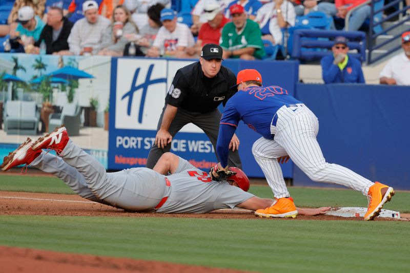 Mar 10, 2025; Port St. Lucie, Florida, USA;  St. Louis Cardinals first base Luken Baker (26) dives back into first base under the tag from New York Mets first base Pete Alonso (20) as umpire Tom Hanahan looks on during the second inning at Clover Park. Mandatory Credit: Reinhold Matay-Imagn Images