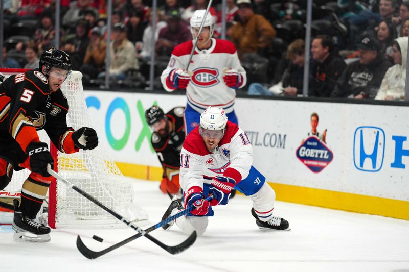 Nov 22, 2023; Anaheim, California, USA; Montreal Canadiens right wing Brendan Gallagher (11) reaches for the puck against Anaheim Ducks defenseman Urho Vaakanainen (5) in the first period at Honda Center. Mandatory Credit: Kirby Lee-USA TODAY Sports