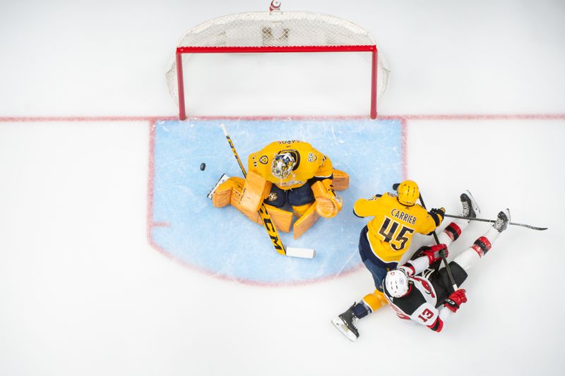 Feb 13, 2024; Nashville, Tennessee, USA;  Nashville Predators goaltender Juuse Saros (74) blocks the shot of New Jersey Devils center Nico Hischier (13) during the first period at Bridgestone Arena. Mandatory Credit: Steve Roberts-USA TODAY Sports