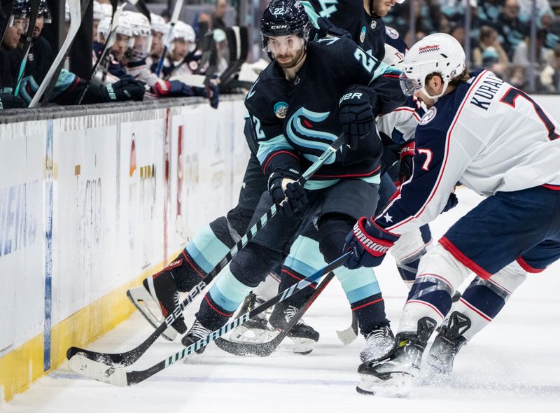 Jan 28, 2024; Seattle, Washington, USA; Seattle Kraken forward Oliver Bjorkstrand (22), left, and Columbus Blue Jackets forward Sean Kuraly (7) battle for the puck during the third period at Climate Pledge Arena. Mandatory Credit: Stephen Brashear-USA TODAY Sports