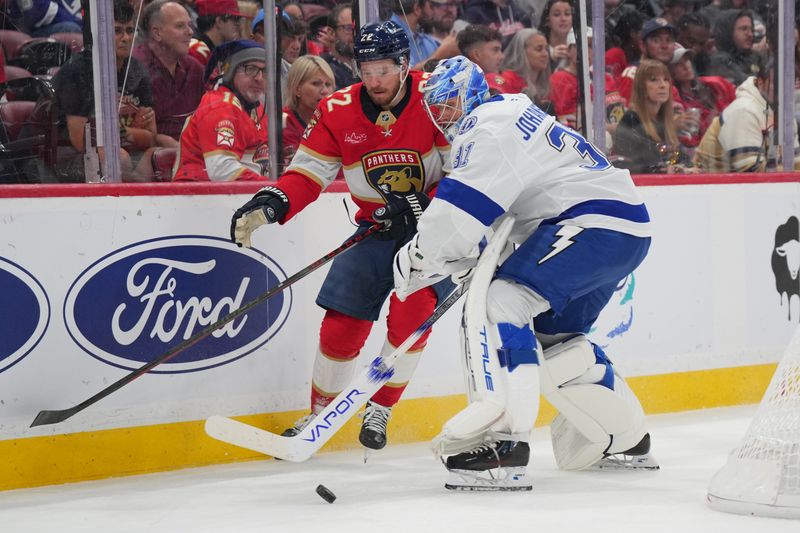 Sep 30, 2024; Sunrise, Florida, USA; Tampa Bay Lightning goaltender Jonas Johansson (31) gets caught out of the net trying to clear the puck as Florida Panthers center Wilmer Skoog (32) closes in during the second period at Amerant Bank Arena. Mandatory Credit: Jim Rassol-Imagn Images