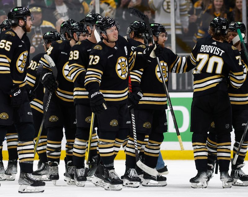 Feb 19, 2024; Boston, Massachusetts, USA; Boston Bruins defenseman Charlie McAvoy (73) smiles as teammates congratulate each other after their 4-3 shootout win over the Dallas Stars at TD Garden. Mandatory Credit: Winslow Townson-USA TODAY Sports