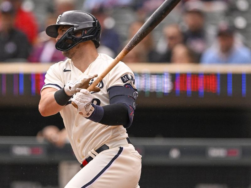 Sep 28, 2023; Minneapolis, Minnesota, USA; Minnesota Twins infielder Kyle Farmer (12) hits a single against the Oakland Athletics during the second inning at Target Field. Mandatory Credit: Nick Wosika-USA TODAY Sports