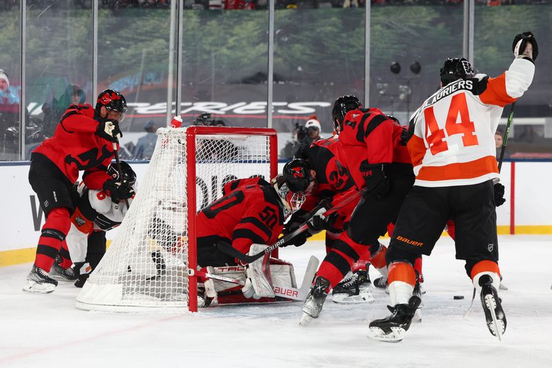 Feb 17, 2024; East Rutherford, New Jersey, USA; New Jersey Devils goaltender Nico Daws (50) makes a save against the Philadelphia Flyers during the first period in a Stadium Series ice hockey game at MetLife Stadium. Mandatory Credit: Ed Mulholland-USA TODAY Sports