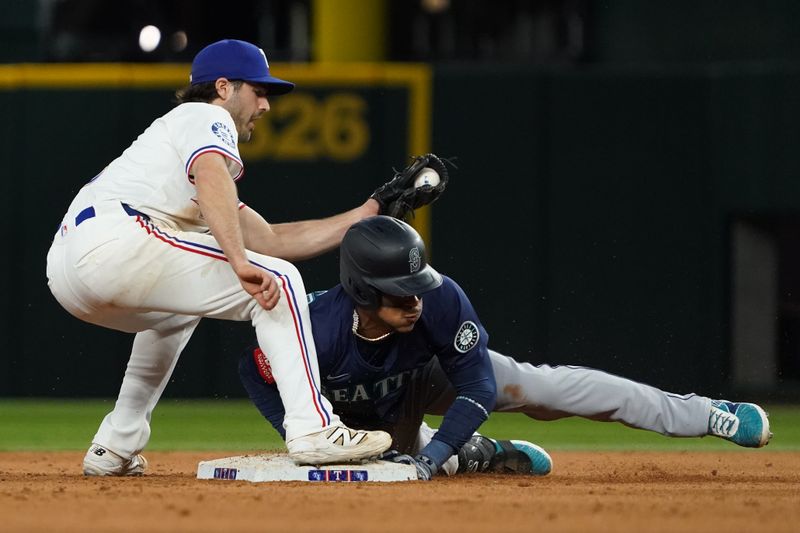 May 3, 2025; Arlington, Texas, USA; Seattle Mariners third baseman Jorge Polanco (7) slides under the tag by Texas Rangers shortstop Josh Smith (8) for a double during the ninth inning against the Texas Rangers at Globe Life Field. Mandatory Credit: Raymond Carlin III-Imagn Images