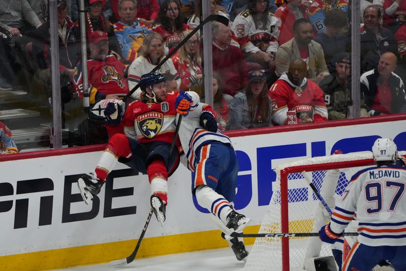 Jun 8, 2024; Sunrise, Florida, USA; Florida Panthers defenseman Josh Mahura (28) is checked into the boards during the first period by the Edmonton Oilers in game one of the 2024 Stanley Cup Final at Amerant Bank Arena. Mandatory Credit: Jim Rassol-USA TODAY Sports