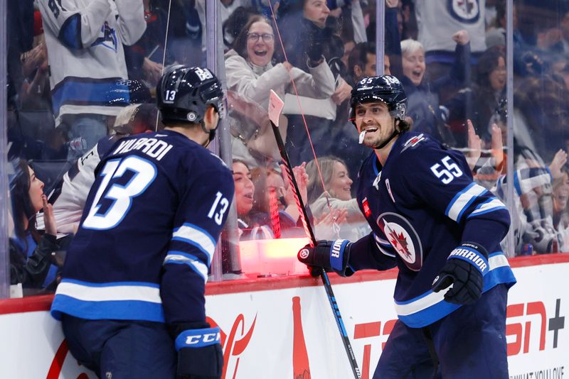 Nov 3, 2024; Winnipeg, Manitoba, CAN; Winnipeg Jets center Mark Scheifele (55) celebrates his second period goal with Winnipeg Jets center Gabriel Vilardi (13) against the Tampa Bay Lightning at Canada Life Centre. Mandatory Credit: James Carey Lauder-Imagn Images