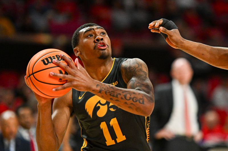 Feb 14, 2024; College Park, Maryland, USA;  Iowa Hawkeyes guard Tony Perkins (11) reacts as Maryland Terrapins forward Jordan Geronimo (22) defends during the first half at Xfinity Center. Mandatory Credit: Tommy Gilligan-USA TODAY Sports