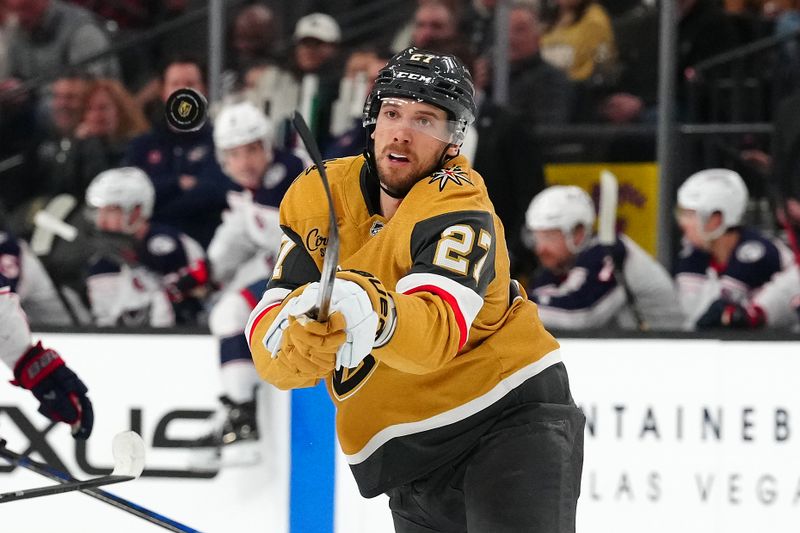 Jan 30, 2025; Las Vegas, Nevada, USA; Vegas Golden Knights defenseman Shea Theodore (27) looks to control a dump in by the Columbus Blue Jackets during the first period at T-Mobile Arena. Mandatory Credit: Stephen R. Sylvanie-Imagn Images