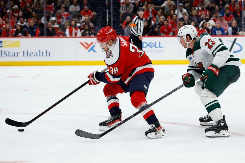 Oct 17, 2025; Washington, District of Columbia, USA; Washington Capitals defenseman Rasmus Sandin (38) skates with the puck against as Minnesota Wild center Marco Rossi (23) chases during the second period at Capital One Arena. Mandatory Credit: Geoff Burke-Imagn Images