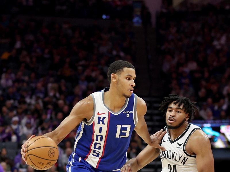 SACRAMENTO, CALIFORNIA - DECEMBER 11: Keegan Murray #13 of the Sacramento Kings dribbles past Cam Thomas #24 of the Brooklyn Nets in the second half at Golden 1 Center on December 11, 2023 in Sacramento, California. NOTE TO USER: User expressly acknowledges and agrees that, by downloading and or using this photograph, User is consenting to the terms and conditions of the Getty Images License Agreement.  (Photo by Ezra Shaw/Getty Images)