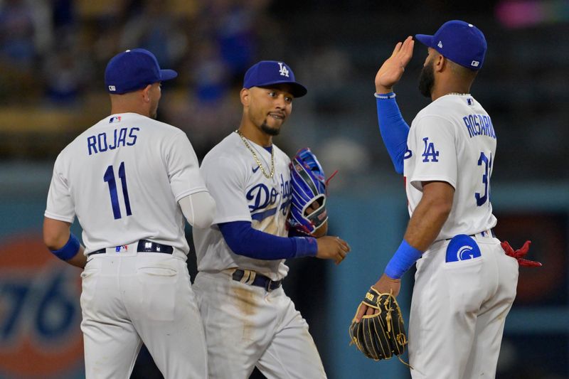 Aug 16, 2023; Los Angeles, California, USA;  Los Angeles Dodgers shortstop Miguel Rojas (11), second baseman Amed Rosario (31) and right fielder Mookie Betts (50) celebrate after the final out of the ninth inning against the Milwaukee Brewers at Dodger Stadium. Mandatory Credit: Jayne Kamin-Oncea-USA TODAY Sports