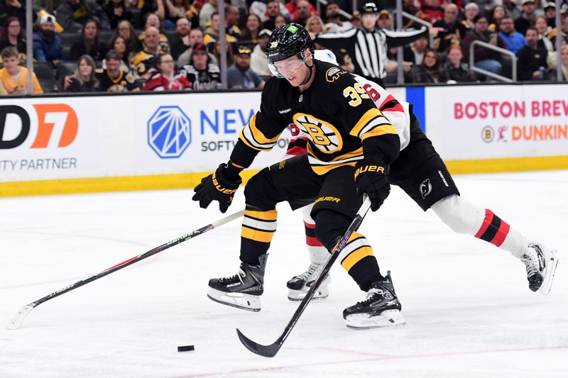 Apr 14, 2026; Boston, Massachusetts, USA; Boston Bruins center Morgan Geekie (39) controls the puck against New Jersey Devils center Jack Hughes (86) during the third period at TD Garden. Mandatory Credit: Bob DeChiara-Imagn Images