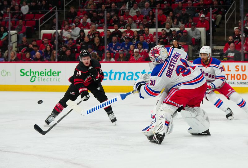 Mar 12, 2024; Raleigh, North Carolina, USA; New York Rangers goaltender Igor Shesterkin (31) clears the puck away from Carolina Hurricanes left wing Jake Guentzel (59) during the first period at PNC Arena. Mandatory Credit: James Guillory-USA TODAY Sports