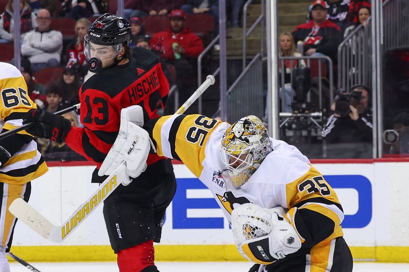 Mar 19, 2024; Newark, New Jersey, USA; Pittsburgh Penguins goaltender Tristan Jarry (35) makes a save through a screen by New Jersey Devils center Nico Hischier (13) during the second period at Prudential Center. Mandatory Credit: Ed Mulholland-USA TODAY Sports