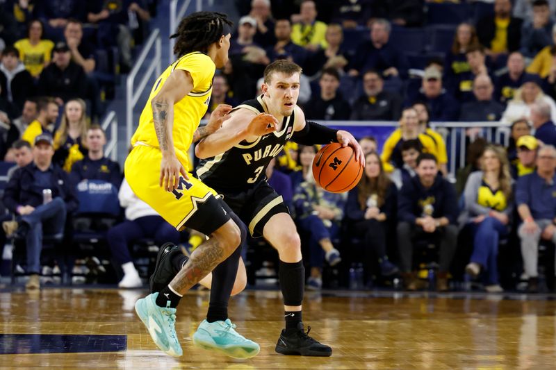 Feb 25, 2024; Ann Arbor, Michigan, USA;  Purdue Boilermakers guard Braden Smith (3) dribbles against Michigan Wolverines guard Dug McDaniel (0) in the second half at Crisler Center. Mandatory Credit: Rick Osentoski-USA TODAY Sports