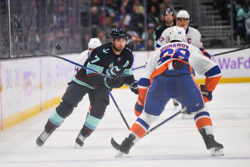 Nov 16, 2023; Seattle, Washington, USA; Seattle Kraken right wing Jordan Eberle (7) passes the puck while defended by New York Islanders defenseman Alexander Romanov (28) during the first period at Climate Pledge Arena. Mandatory Credit: Steven Bisig-USA TODAY Sports