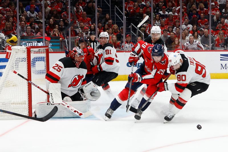 Oct 12, 2024; Washington, District of Columbia, USA; Washington Capitals center Hendrix Lapierre (29) and New Jersey Devils left wing Tomas Tatar (90) battle for the puck in the third period at Capital One Arena. Mandatory Credit: Geoff Burke-Imagn Images