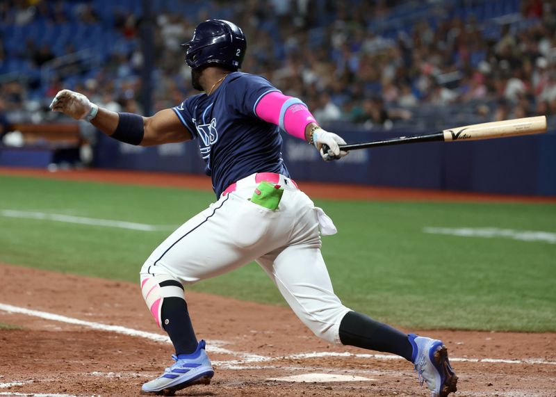 Jun 24, 2024; St. Petersburg, Florida, USA; Tampa Bay Rays first base Yandy Díaz (2) hits a two-RBI single against the Seattle Mariners during the eighth inning  at Tropicana Field. Mandatory Credit: Kim Klement Neitzel-USA TODAY Sports