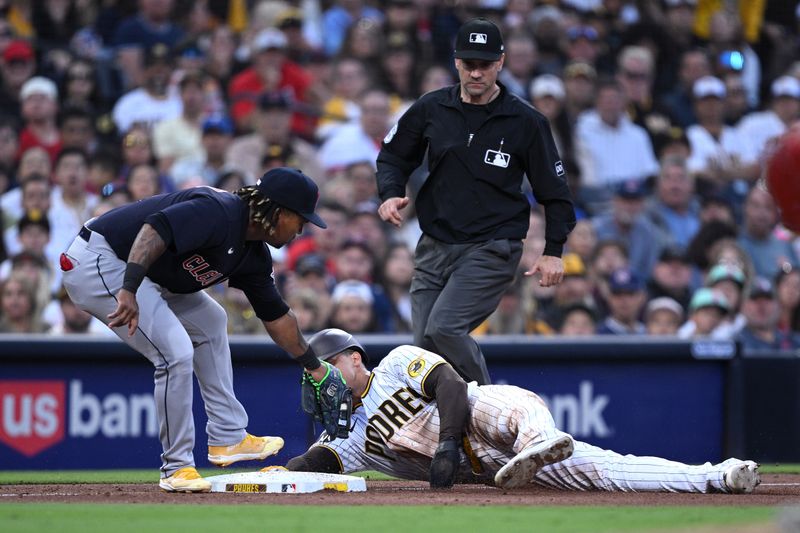 Jun 15, 2023; San Diego, California, USA; San Diego Padres left fielder Juan Soto (bottom) is tagged out at third base by Cleveland Guardians third baseman Jose Ramirez (left) as umpire David Rackley (top) looks on during the sixth inning at Petco Park. Mandatory Credit: Orlando Ramirez-USA TODAY Sports