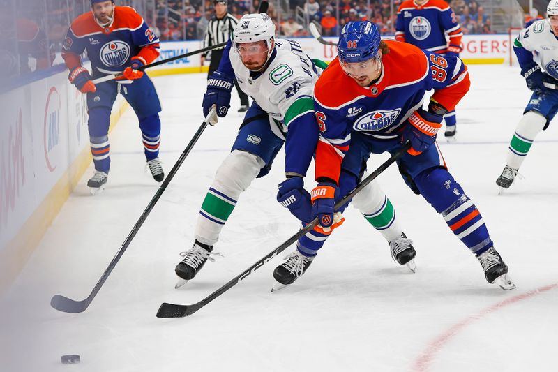 Oct 11, 2025; Edmonton, Alberta, CAN; Edmonton Oilers forward David Tomasek (86) and Vancouver Canucks defensemen Marcus Pettersson (29) battle for a loose puck during the first period at Rogers Place. Mandatory Credit: Perry Nelson-Imagn Images