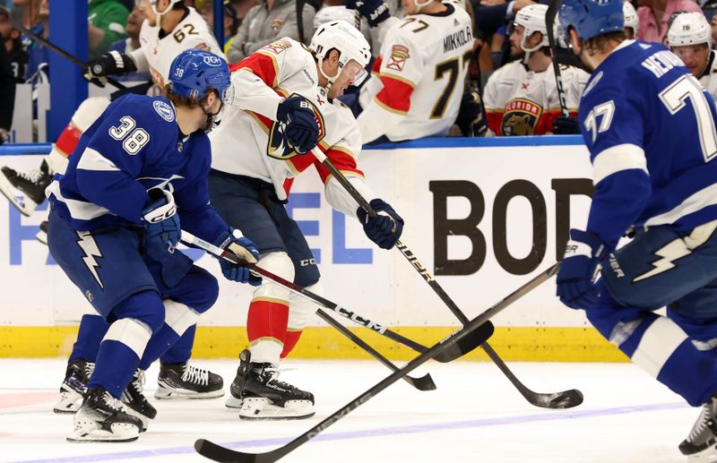 Apr 25, 2024; Tampa, Florida, USA; Florida Panthers center Carter Verhaeghe (23) skates with the puck as Tampa Bay Lightning left wing Brandon Hagel (38) and defenseman Victor Hedman (77) defend during the second period in game three of the first round of the 2024 Stanley Cup Playoffs at Amalie Arena. Mandatory Credit: Kim Klement Neitzel-USA TODAY Sports