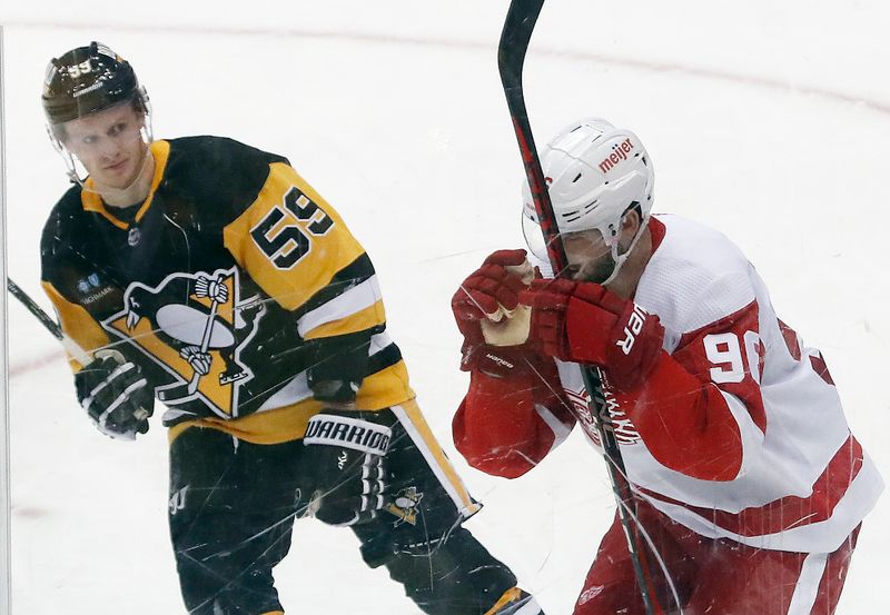 Dec 28, 2022; Pittsburgh, Pennsylvania, USA;  Detroit Red Wings defenseman Jake Walman (96) reacts after scoring the game winning goal as Pittsburgh Penguins left wing Jake Guentzel (59) looks on in overtime at PPG Paints Arena. Detroit won 5-4 in overtime. Mandatory Credit: Charles LeClaire-USA TODAY Sports