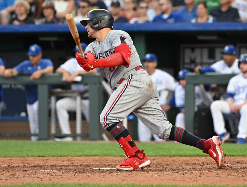 Jul 29, 2023; Kansas City, Missouri, USA;  Minnesota Twins catcher Christian Vazquez (8) hits an RBI single during the sixth inning against the Kansas City Royals at Kauffman Stadium. Mandatory Credit: Peter Aiken-USA TODAY Sports