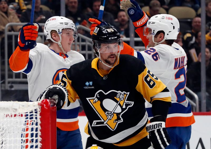 Feb 20, 2024; Pittsburgh, Pennsylvania, USA; New York Islanders right wing Simon Holmstrom (left) celebrates his goal with right wing Oliver Wahlstrom (26) as Pittsburgh Penguins defenseman Erik Karlsson (65) reacts during the second period at PPG Paints Arena. New York won 5-4 in overtime.Mandatory Credit: Charles LeClaire-USA TODAY Sports