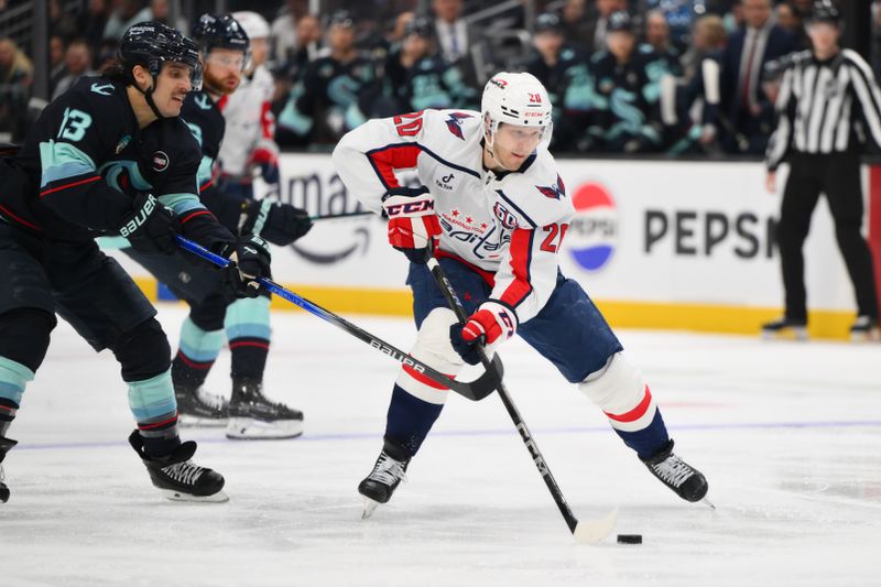 Jan 23, 2025; Seattle, Washington, USA; Washington Capitals center Lars Eller (20) plays the puck while defended by Seattle Kraken left wing Brandon Tanev (13) during the second period at Climate Pledge Arena. Mandatory Credit: Steven Bisig-Imagn Images