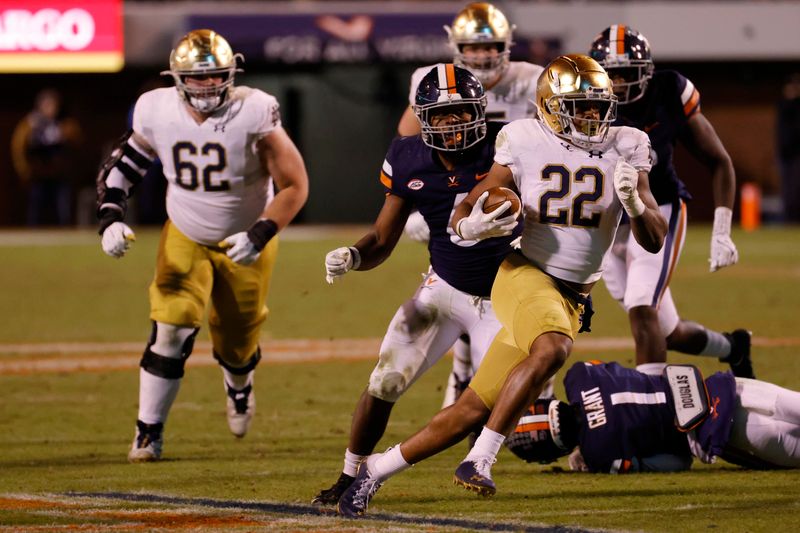 Nov 13, 2021; Charlottesville, Virginia, USA; Notre Dame Fighting Irish running back Logan Diggs (22) carries the ball past Virginia Cavaliers inside linebacker Nick Jackson (6) during the fourth quarter at Scott Stadium. Mandatory Credit: Geoff Burke-USA TODAY Sports