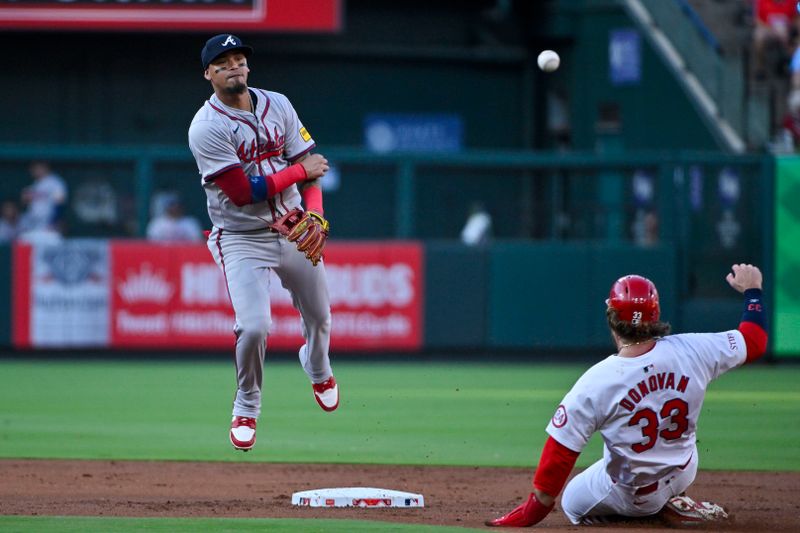 Jun 24, 2024; St. Louis, Missouri, USA;  Atlanta Braves shortstop Orlando Arcia (11) leaps as he throws to first after forcing St. Louis Cardinals left fielder Brendan Donovan (33) during the second inning at Busch Stadium. Mandatory Credit: Jeff Curry-USA TODAY Sports