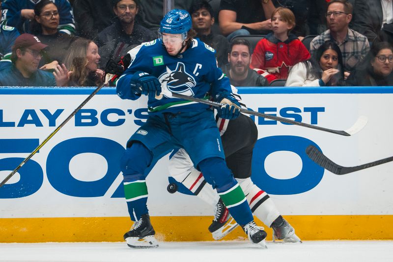 Nov 5, 2025; Vancouver, British Columbia, CAN; Vancouver Canucks defenseman Quinn Hughes (43) checks Chicago Blackhawks forward Connor Bedard (98) in the first period at Rogers Arena. Mandatory Credit: Bob Frid-Imagn Images