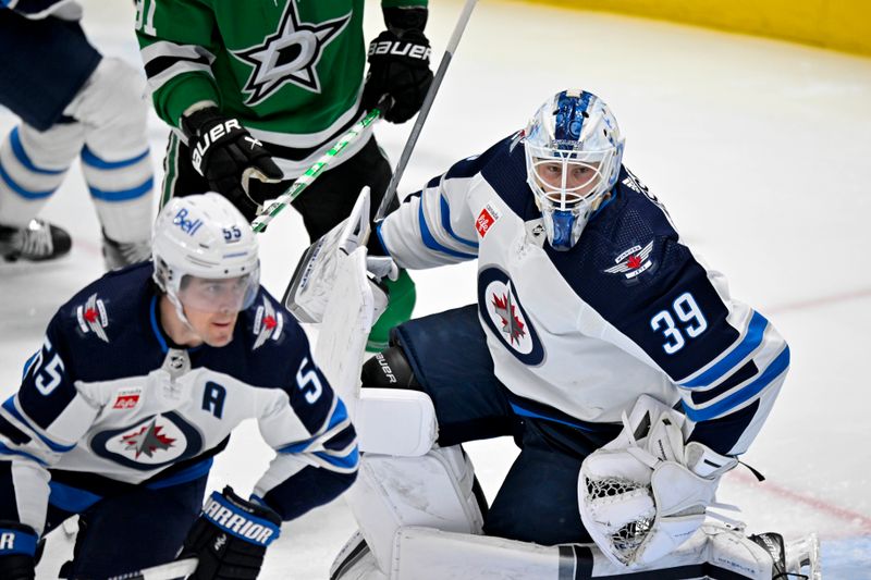 Apr 11, 2024; Dallas, Texas, USA; Winnipeg Jets center Mark Scheifele (55) and goaltender Laurent Brossoit (39) faces the Dallas Stars attack during the second period at the American Airlines Center. Mandatory Credit: Jerome Miron-USA TODAY Sports