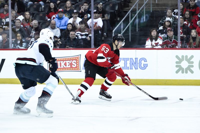 Feb 12, 2024; Newark, New Jersey, USA; New Jersey Devils left wing Jesper Bratt (63) skates with the puck as Seattle Kraken defenseman Ryker Evans (39) defends during the second period at Prudential Center. Mandatory Credit: John Jones-USA TODAY Sports