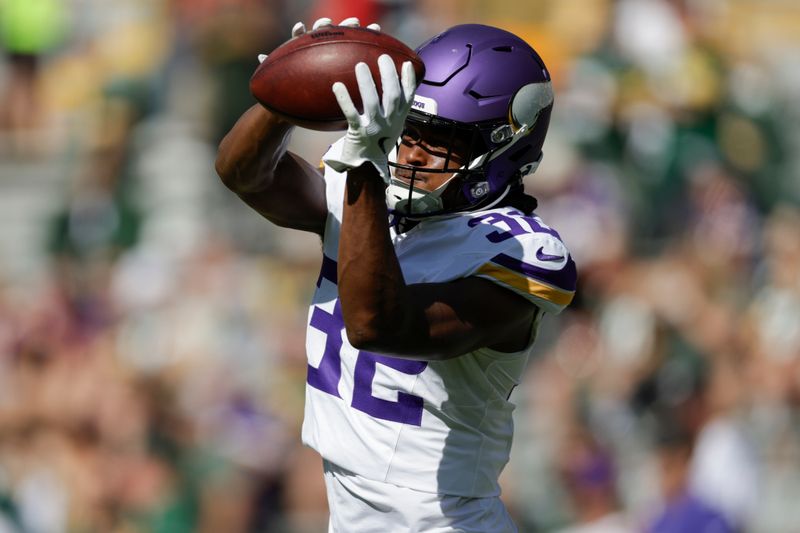 Minnesota Vikings running back Ty Chandler (32) warms up before an NFL football game against the Green Bay Packers, Sunday, Sept. 29, 2024, in Green Bay, Wis. (AP Photo/Matt Ludtke)