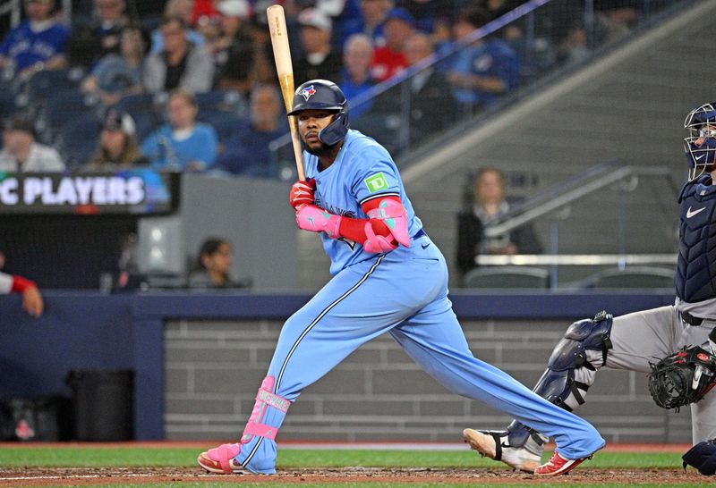 Sep 24, 2024; Toronto, Ontario, CAN;  Toronto Blue Jays designated hitter Vladimir Guerrero Jr. (27) looks for a signal from third base coach Mark Budzinski (not shown) in the eighth inning at Rogers Centre. Mandatory Credit: Dan Hamilton-Imagn Images