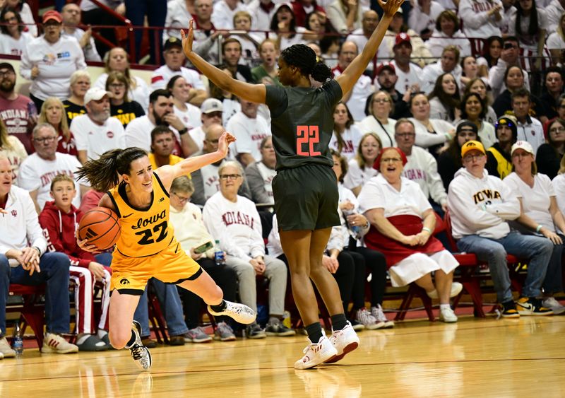 Feb 22, 2024; Bloomington, Indiana, USA; Iowa Hawkeyes guard Caitlin Clark (22) falls while looking for a teammate around Indiana Hoosiers guard Chloe Moore-McNeil (22) during the first quarter at Simon Skjodt Assembly Hall. Mandatory Credit: Marc Lebryk-USA TODAY Sports